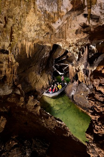 Grotte de Labouiche (Ariège) - Groupe de touristes dans une barque admirant les concrétions(SP-23-1577)